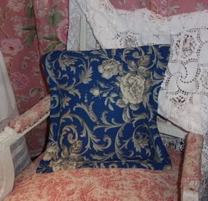 Un coussin réalisé en tissu ancien , motifs de roses, fond bleu